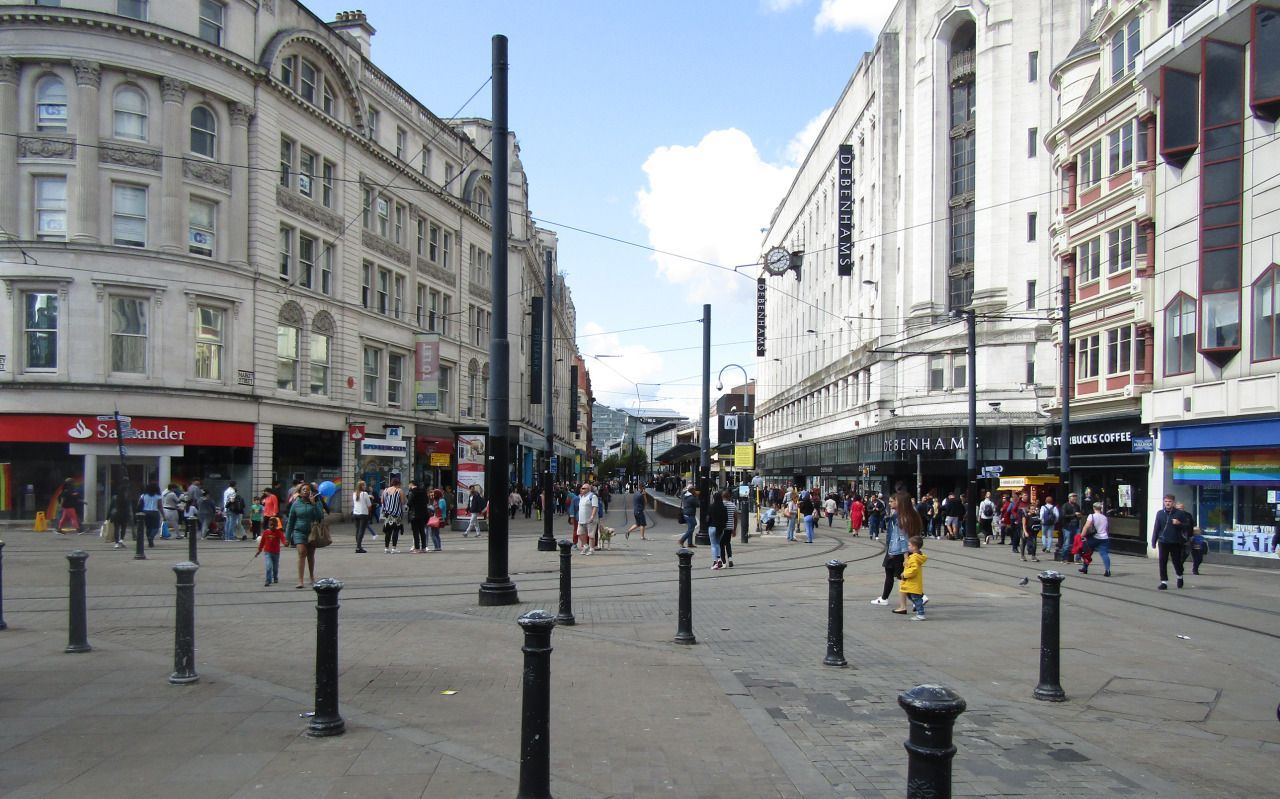 A photograph showing a street in Manchester, taken from within Picadilly Gardens.